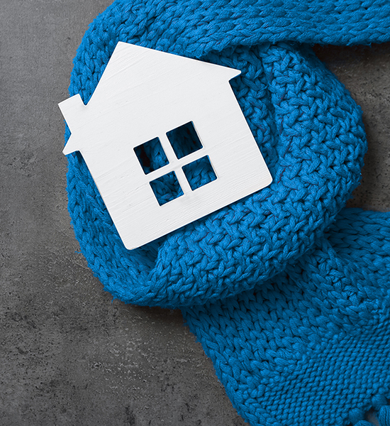 Wooden house model and blue scarf on grey stone background