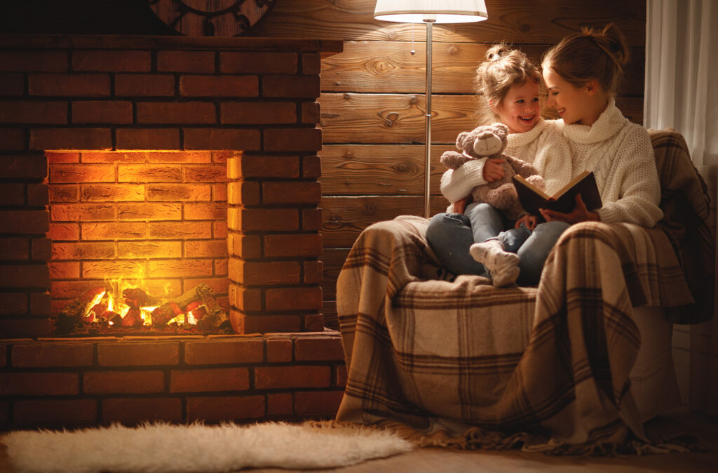 Gas vs. Electric Heating Heating Services
happy family mother and child daughter read book on winter evening near fireplace
