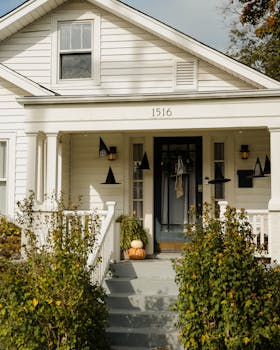 Your 5 End-of-Season HVAC Maintenance Tips A cozy house with pumpkins and witch hats decorated for Halloween.