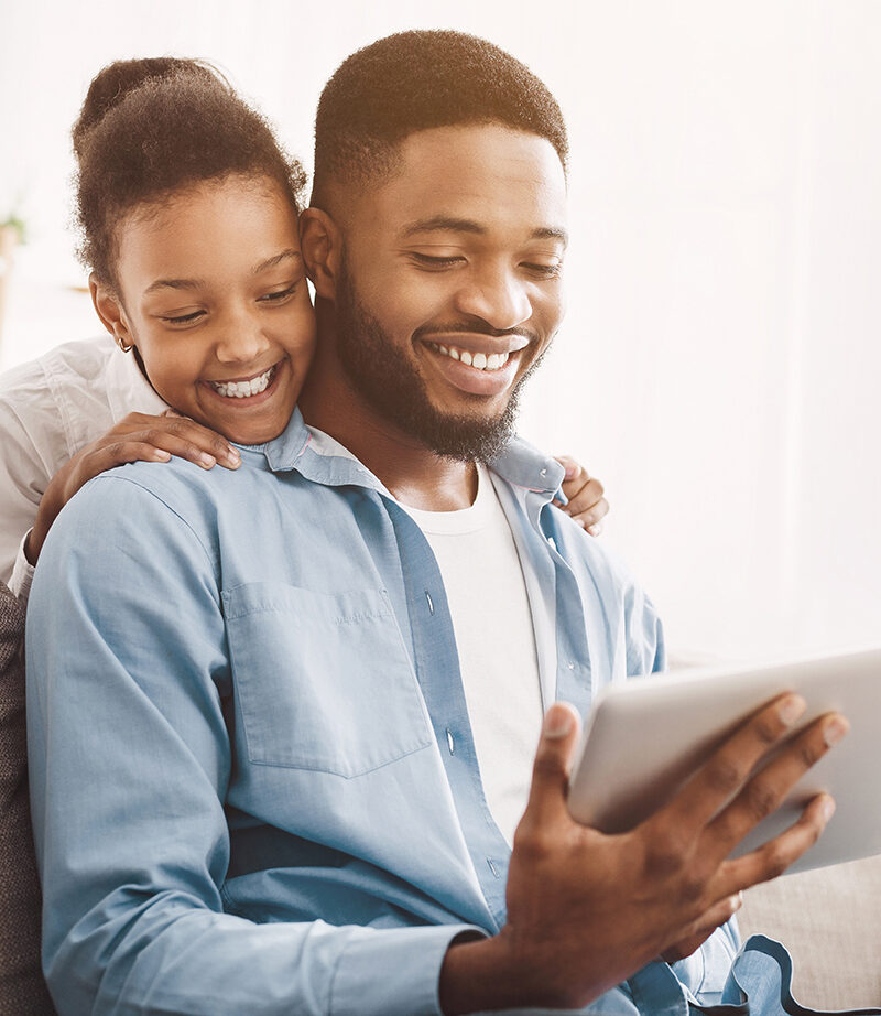 Father and daughter having video call on tablet